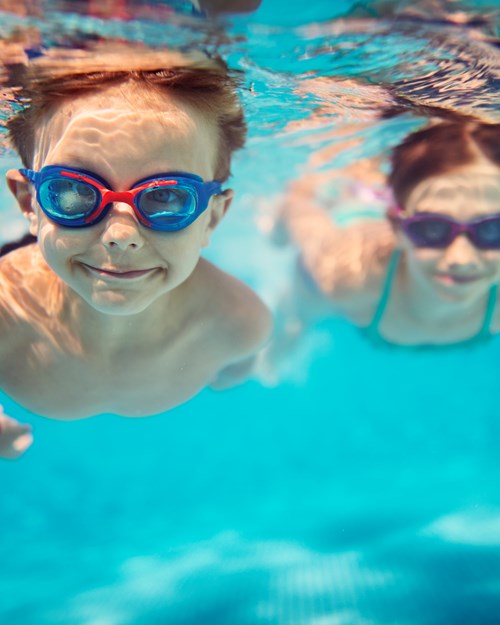 Happy children swimming underwater in pool