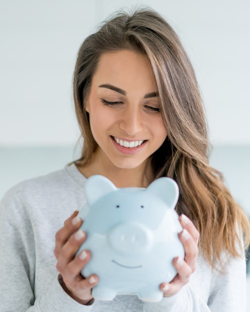 Happy woman saving money in a piggybank